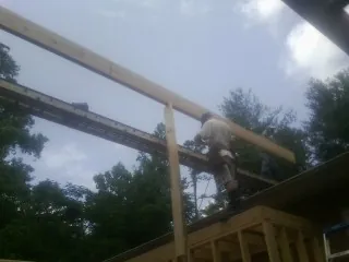 Carpenter setting a ridge beam over a new addition frame — Ice Dam Removal by Roofing Brothers in New Ringgold